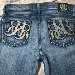 Roc& Republic boot cut jeans with gray emblem pockets. Soft blue jean wash.